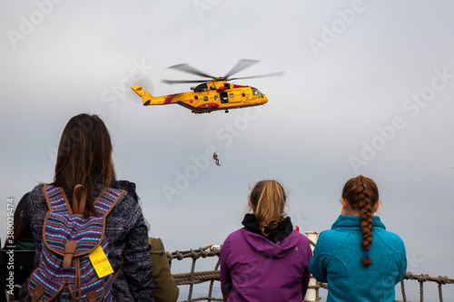 Photo While onboard a Warship from the Canadian Forces Base in Esquimalt, British Columbia, a group of women watch a search and rescue demonstration of a CH-149 Cormorant Search and Rescue Aircraft