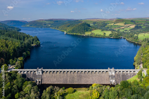 Aerial view of a huge lake surrounded by rural farmland and forest. (Lake Vyrnwy, Wales)