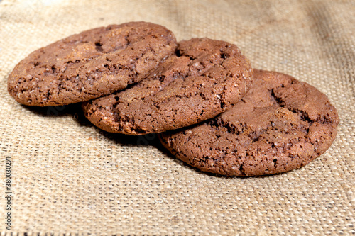 Three Shekoladno oatmeal cookies on sackcloth concept homemade baking close up
