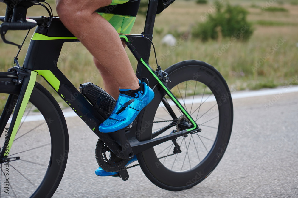 closeup of triathlon athlete riding bike closeup of triathlon athlete riding bike