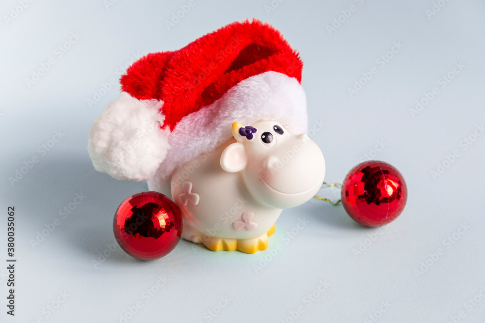 Cow in a santa hat as a symbol of the year 2021 with snowflake on the background. Festive christmas decoration Cow in a santa hat as a symbol of the year 2021 with snowflake on the background. Festive christmas decoration