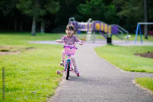 young girl ridding bicycle on summer garden morning © M-image