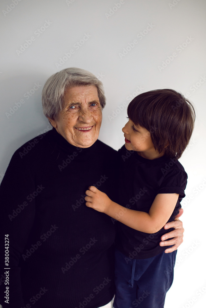 funny grandson in a black t-shirt stands funny grandson in a black t-shirt stands