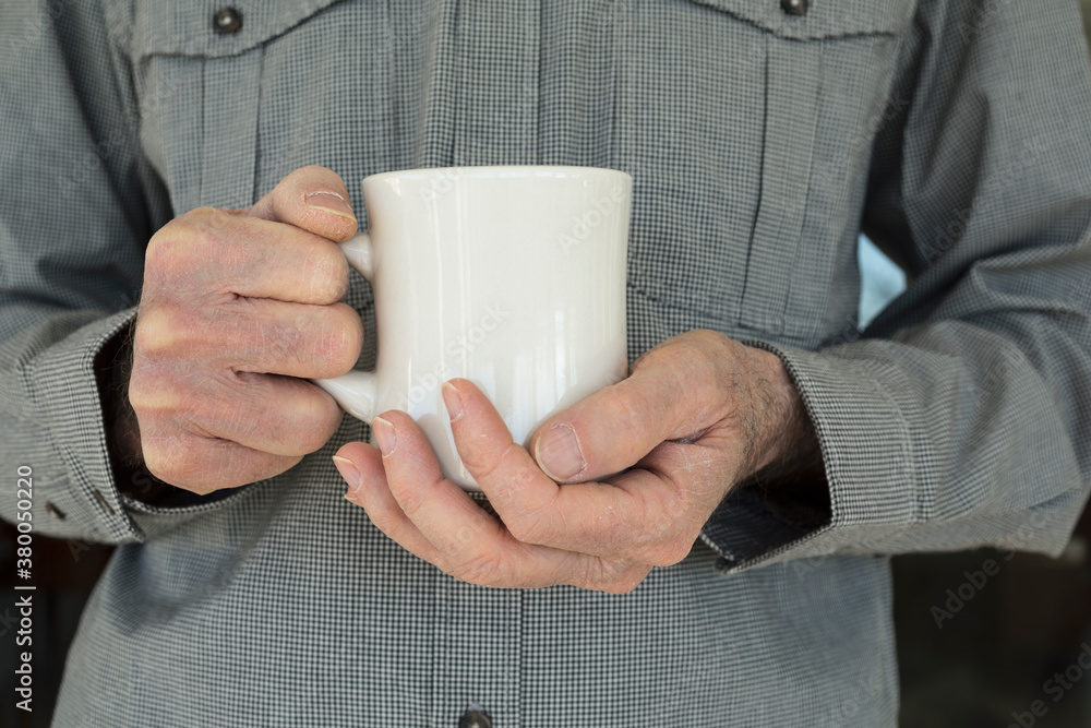Man holding a white coffee mug with both hands Man holding a white coffee mug with both hands