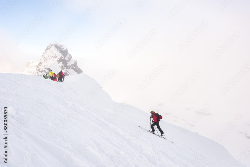 Skier ascending on the top of the snow covered summit Skier ascending on the top of the snow covered summit