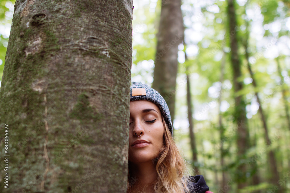 Portrait of young woman behind a tree Portrait of young woman behind a tree