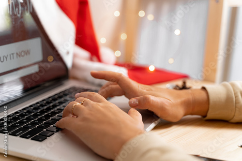 Close up of hands on laptop keyboard on christmas day. Online shopping. Quarantine celebration © troyanphoto