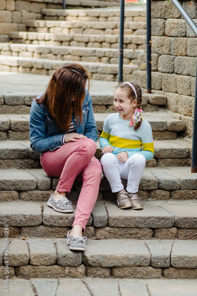Mother and daughter sitting on steps talking Mother and daughter sitting on steps talking