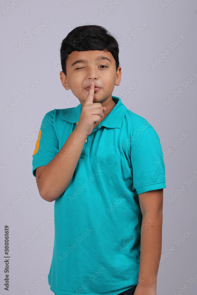 Mischievous Indian boy winking, isolated over white background. Mischievous Indian boy winking, isolated over white background.