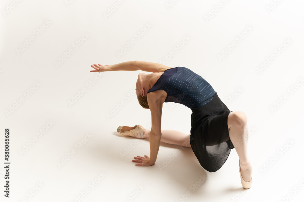 Naklejka premium Ballerina in pointe shoes and in a tutu on a light background dance correct positioning of the legs slim figure