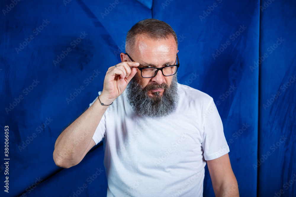 Adult male mentor, director, businessman in glasses and a suit studying documents while sitting at the table. Working day concept Adult male mentor, director, businessman in glasses and a suit studying documents while sitting at the table. Working day concept