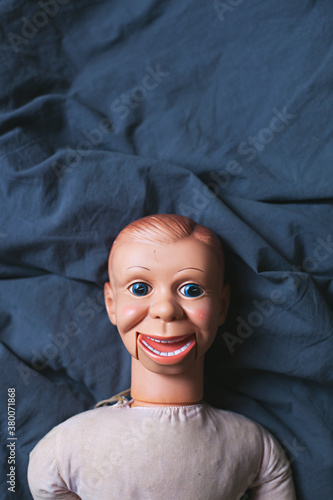 Creepy talking doll lying on a bed photo
