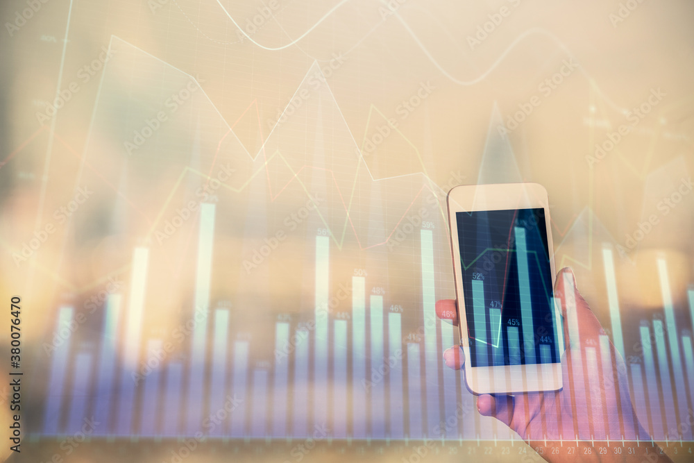 Double exposure of forex chart sketch hologram and woman holding and using a mobile device. Stock market concept. Double exposure of forex chart sketch hologram and woman holding and using a mobile device. Stock market concept.
