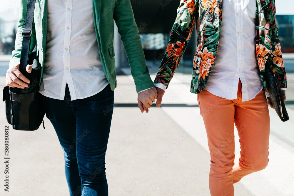 Stylish gay couple walking hand in hand. Stylish gay couple walking hand in hand.