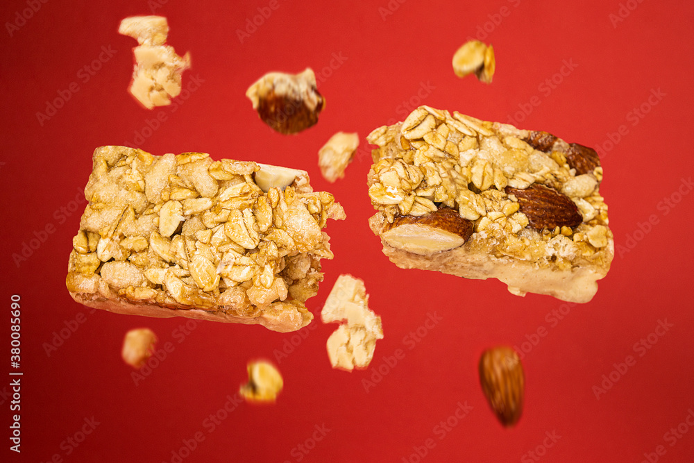 granola bar broken in half floating on red phone with pieces of walnut oats grains cereals falling down healthy
granola bar broken in half floating on red phone with pieces of walnut oats grains cereals falling down healthy