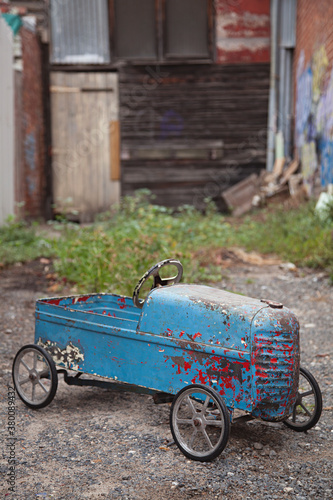 Retro vintage old children's pedal car toy in laneway photo