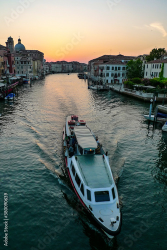 Sunrise, as passenger boat travels along the Grand Canal