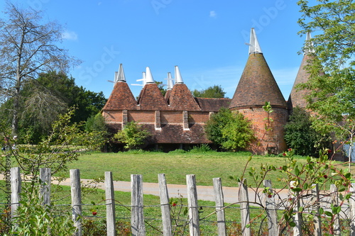 Traditional oast house building found in Kent and Sussex counties. It is a freestanding kiln with a plenum chamber fired by charcoal at ground level and above drying floor for hops used in beer making