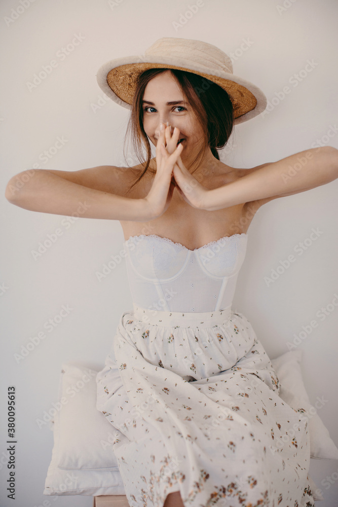 Smiling woman in sailor hat hide half of her face behind the hands Smiling woman in sailor hat hide half of her face behind the hands