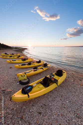 Yellow kayaks alligned on the seashore photo