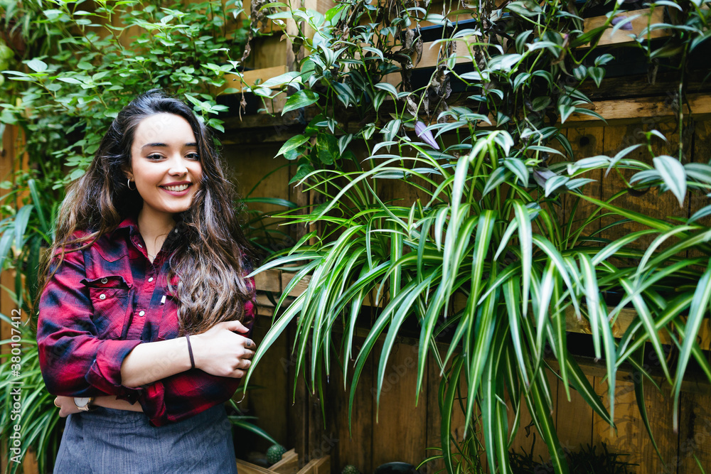 Young woman watering a vertical home garden . Young woman watering a vertical home garden .