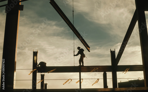 Lone Construction Worker Standing on Beam at Construction Site photo