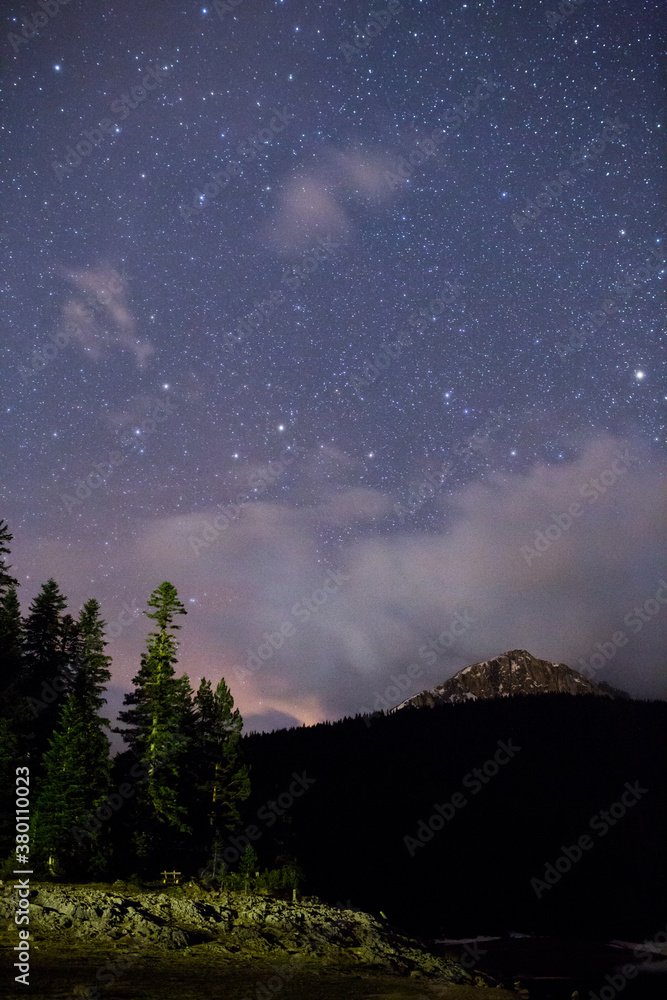 Rocky mountain peak covered with snow under the sky full of stars Rocky mountain peak covered with snow under the sky full of stars