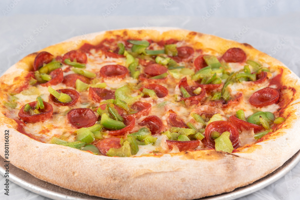 Healthy sized pepperoni and green pepper pizza with thick crust to complete a delicious meal to eat