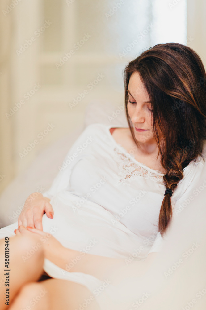 Relaxed woman caressing her pregnant belly Relaxed woman caressing her pregnant belly