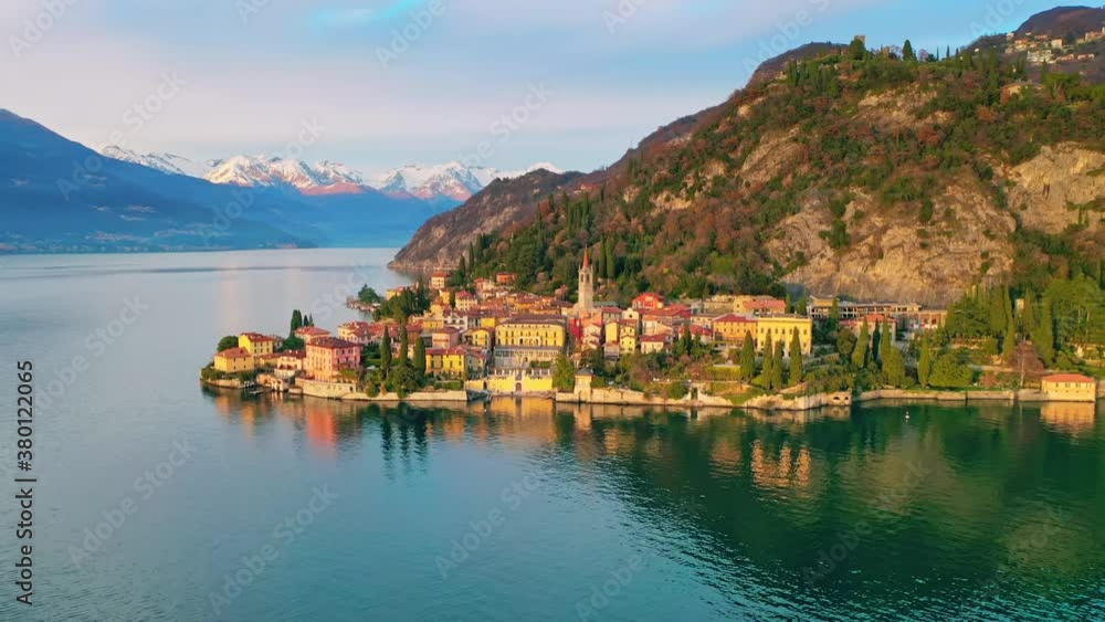 Italian Lake Como and Varenna town landscape at sunset, Alps snowy mountain background Italian Lake Como and Varenna town landscape at sunset, Alps snowy mountain background