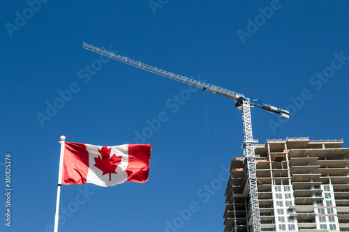 Canadian flag with apartment building under construction in the background, Canadian economy and housing market