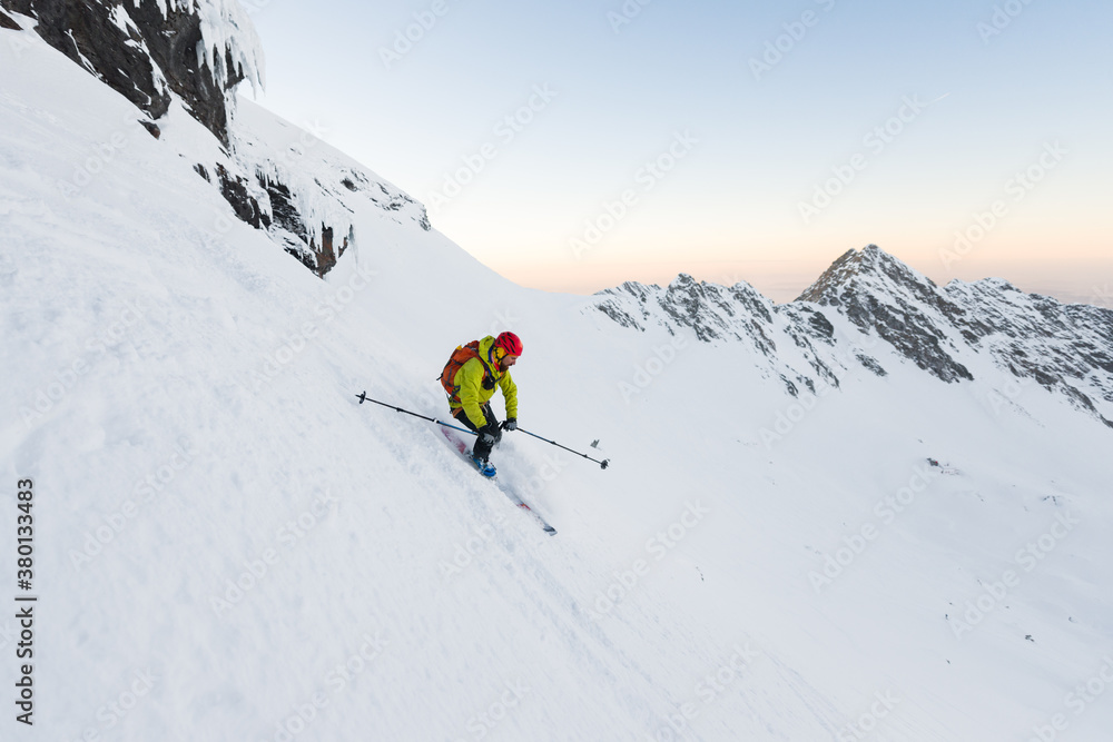 Man skiing off piste downhill steep slope during sunset Man skiing off piste downhill steep slope during sunset