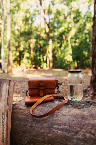 hipster bag and notebook with water in outdoors setting photo