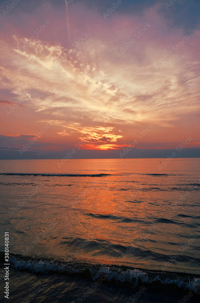 Obraz premium Beautiful sunset along the coast with purple and pink sky