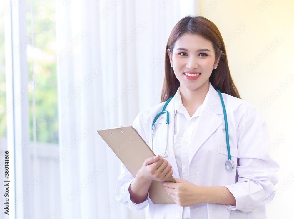 Asian female doctor standing wearing a white robe and stethoscope Asian female doctor standing wearing a white robe and stethoscope