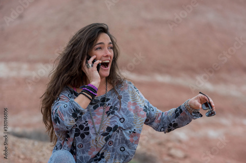 Mujer joven, recibe buenas noticias en su teléfono móvil, disfrutando del aire libre. photo