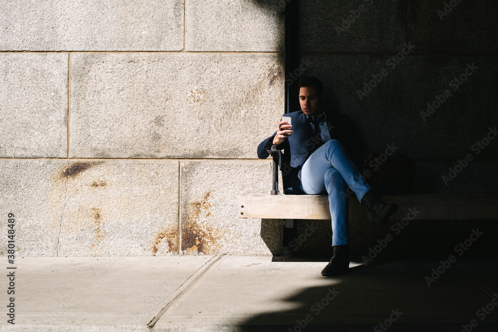 Real businessman sitting in the shadow using technology