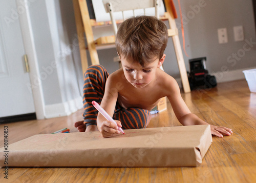 child writes on brown paper package photo