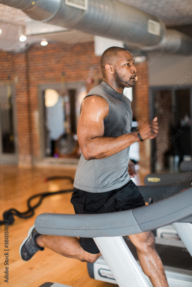 Muscular man running on a treadmill Muscular man running on a treadmill