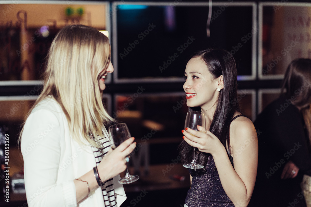 Young Women in Conversation at a Party or Bar Young Women in Conversation at a Party or Bar