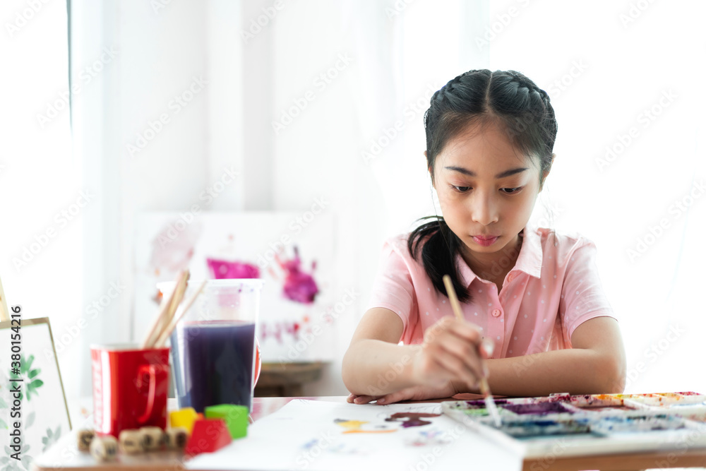 Little girl artist drawing on canvas with color palette and watercolor paints at home Little girl artist drawing on canvas with color palette and watercolor paints at home
