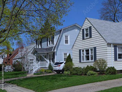 Residential street with modest detached houses with aluminum siding or clapboard photo