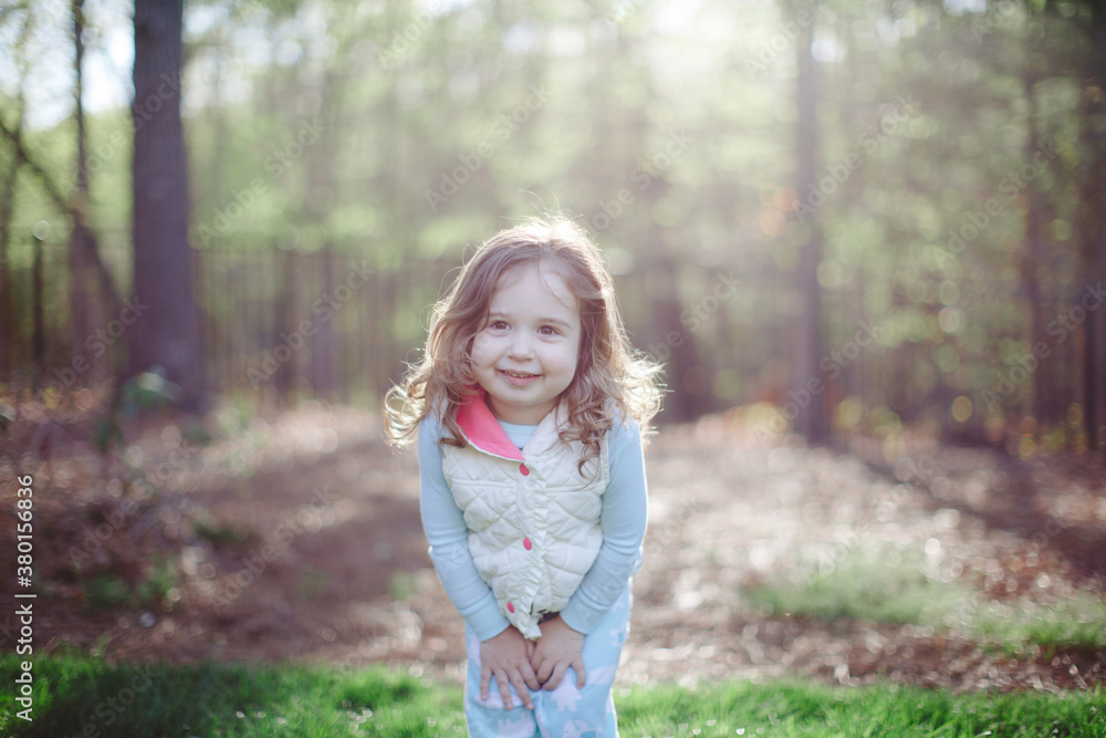 Happy toddler standing outside by a forest Happy toddler standing outside by a forest