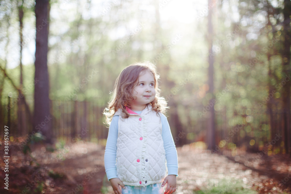 Happy toddler standing outside by a forest Happy toddler standing outside by a forest
