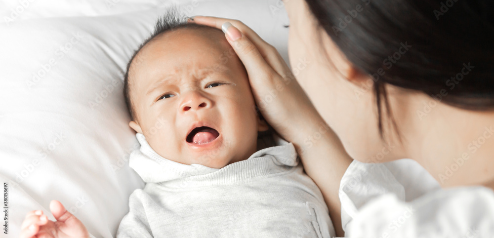 Portrait of enjoy happy love family asian mother playing with adorable little asian baby.Mom touching with cute son moments good time in a white bedroom.Love of family concept Portrait of enjoy happy love family asian mother playing with adorable little asian baby.Mom touching with cute son moments good time in a white bedroom.Love of family concept