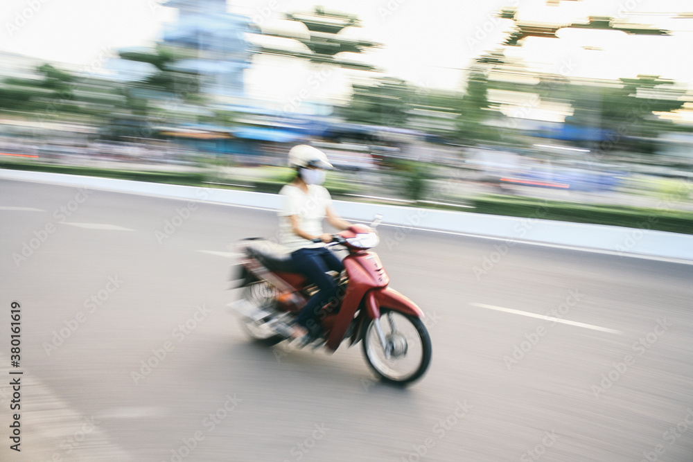 Young woman riding a motorbike - moped. Speed blurred image Young woman riding a motorbike - moped. Speed blurred image
