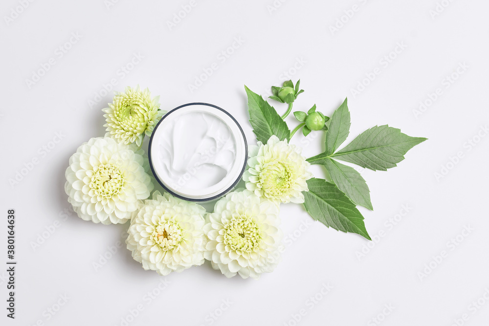 spa concept or template for salon treatment invitation. florals compositions made white flowers and skincare cream. simple flat lay, close-up spa concept or template for salon treatment invitation. florals compositions made white flowers and skincare cream. simple flat lay, close-up