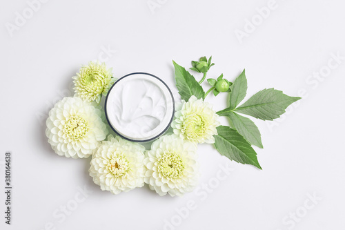 spa concept or template for salon treatment invitation. florals compositions made white flowers and skincare cream. simple flat lay, close-up