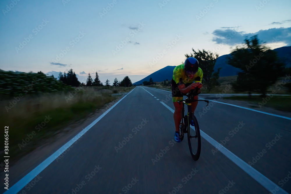 Fototapeta premium triathlon athlete riding bike at night