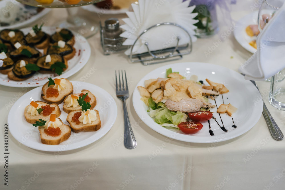 Caesar salad and other various snacks on the festive table Caesar salad and other various snacks on the festive table